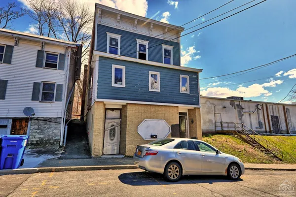 a car parked in front of a brick house