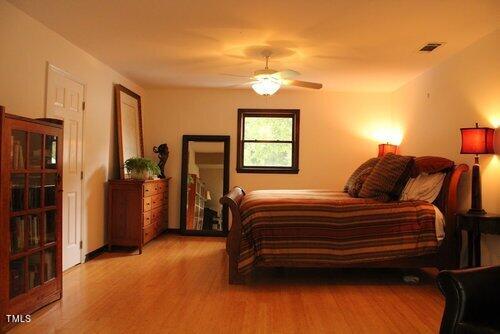568 Log Barn Road Pittsboro, NC 27312 - Photo 13 of 25 a bedroom with a bed and a night stand