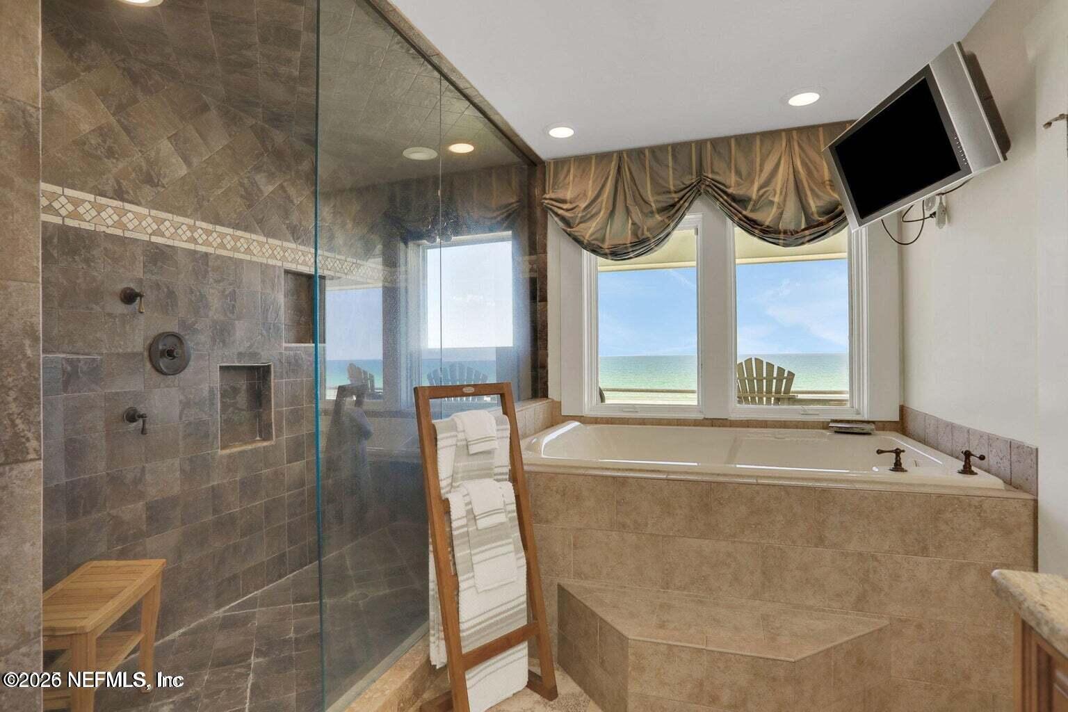 1403 Ocean Front Neptune Beach, FL 32266 - Photo 27 of 37 a bathroom with a large tub a shower and sink
