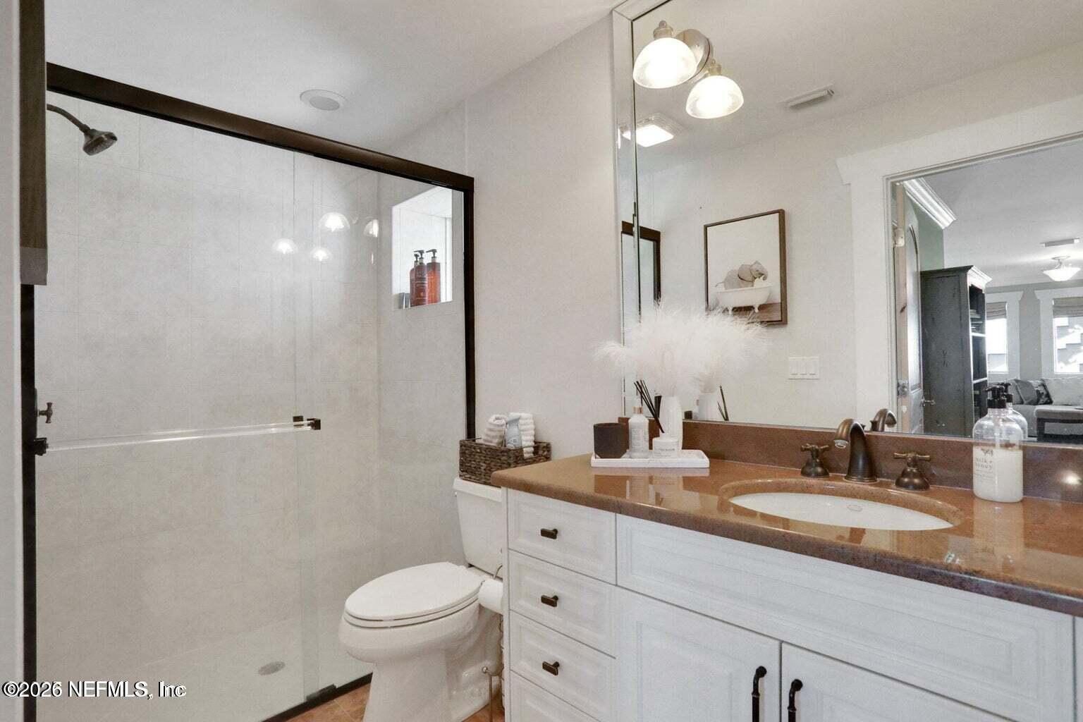 1403 Ocean Front Neptune Beach, FL 32266 - Photo 30 of 37 a bathroom with a granite countertop sink toilet and a mirror