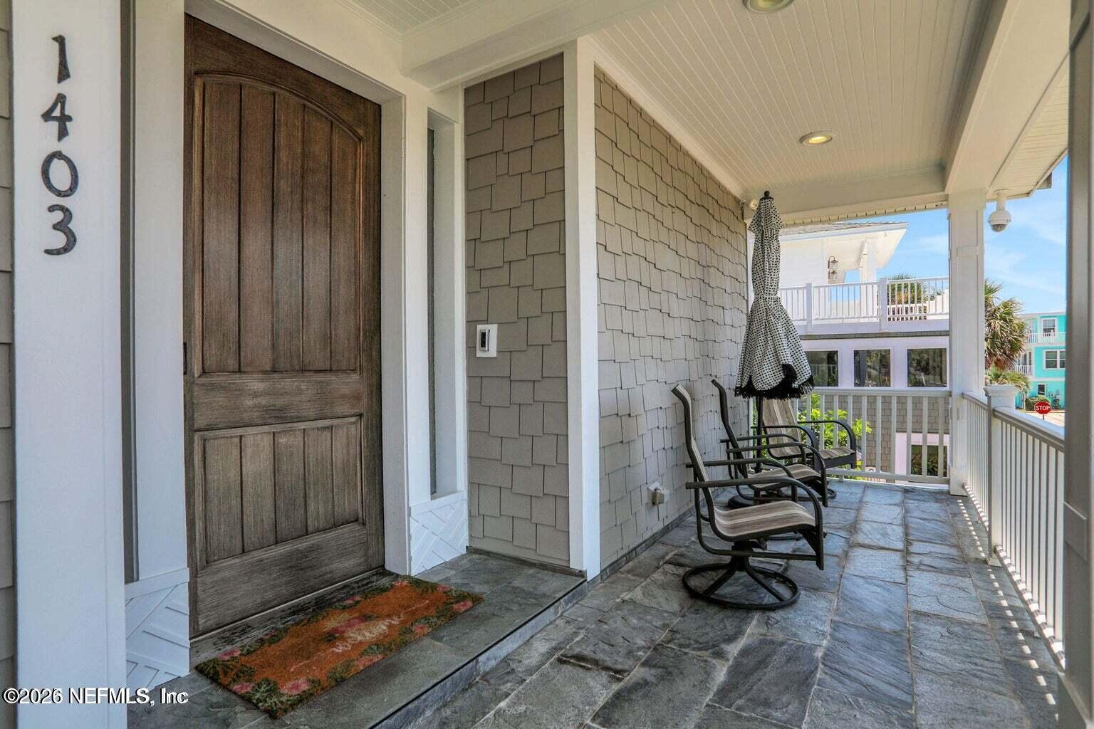 1403 Ocean Front Neptune Beach, FL 32266 - Photo 6 of 37 a porch with seating area and glass door