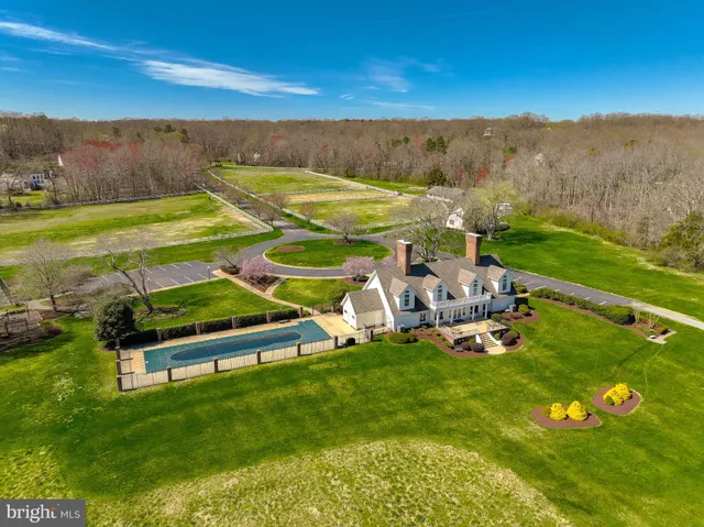 a view of a swimming pool with lawn chairs and couches