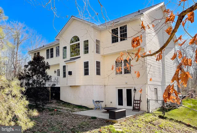 a view of a white house with large windows and a yard