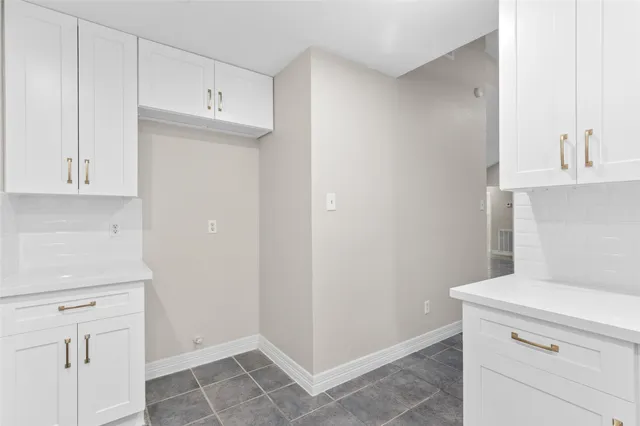 a view of a kitchen with white cabinets