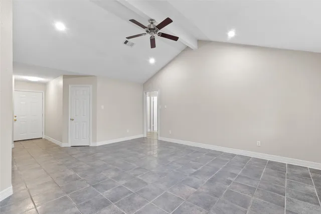 an empty room with windows and ceiling fan