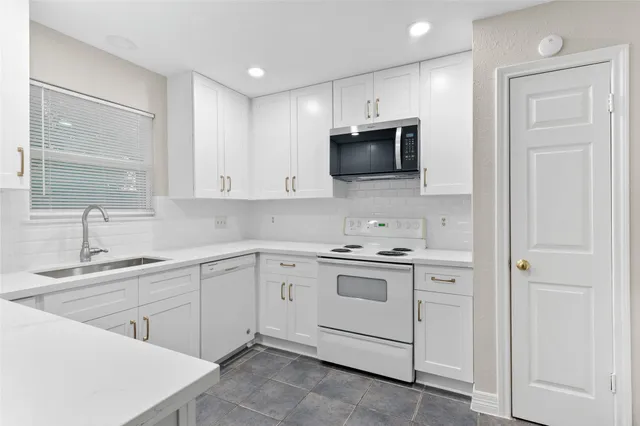 a kitchen with white cabinets stainless steel appliances and sink