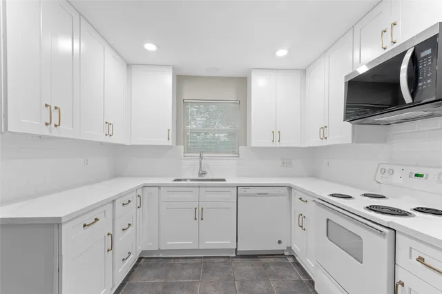 a kitchen with white cabinets stainless steel appliances and sink