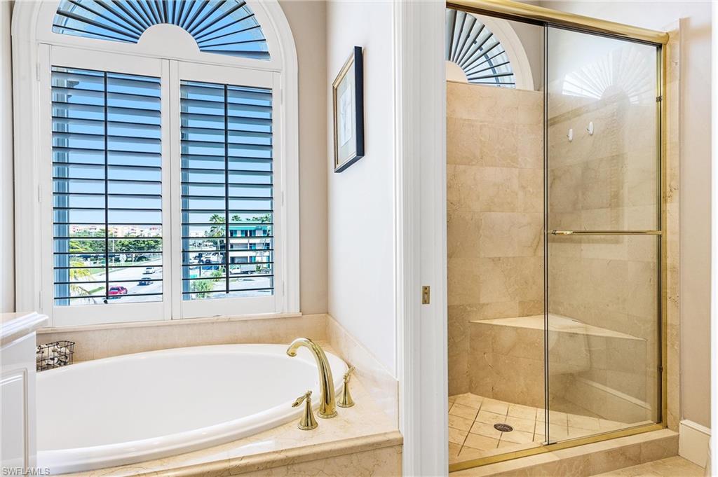 900 5th Avenue South, Unit 301 Naples, FL 34102 - Photo 11 of 18 a bathroom with a bathtub and next to a window
