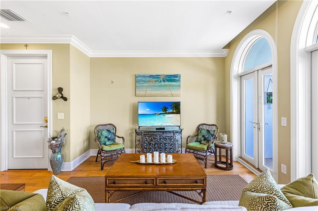 900 5th Avenue South, Unit 301 Naples, FL 34102 - Photo 2 of 18 a living room with furniture and a flat screen tv
