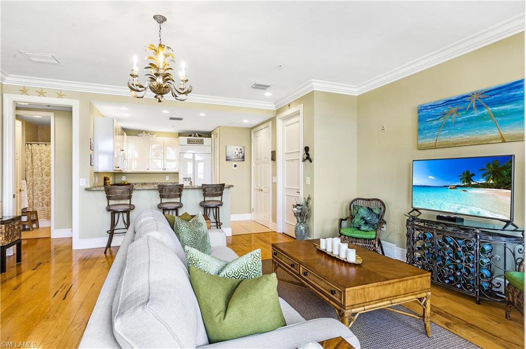 900 5th Avenue South, Unit 301 Naples, FL 34102 - Photo 3 of 18 a living room with furniture and a chandelier