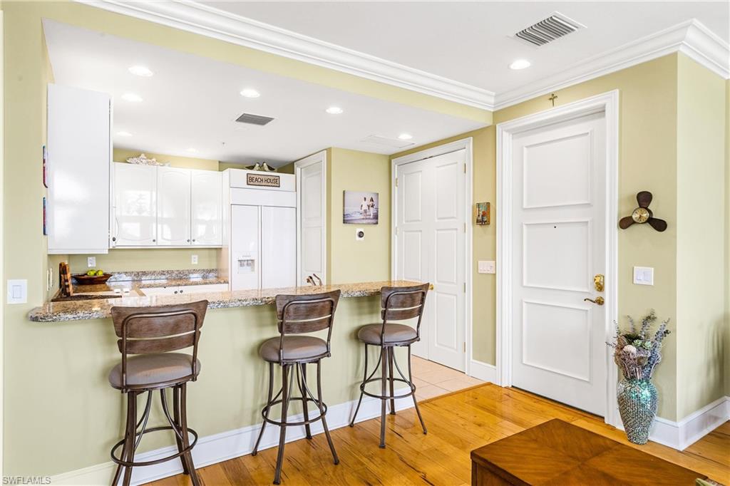 900 5th Avenue South, Unit 301 Naples, FL 34102 - Photo 6 of 18 a kitchen with a table and chairs in it