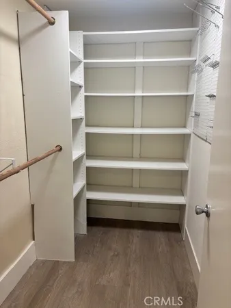 a view of walk in closet with empty racks