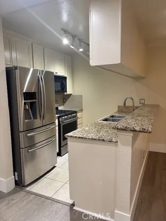 a kitchen with stainless steel appliances granite countertop a refrigerator sink and stove