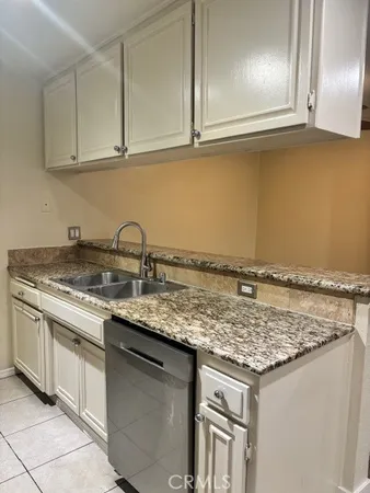 a kitchen with granite countertop a sink and cabinets