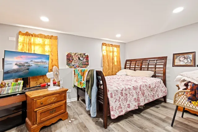 a bedroom with a bed and wooden floor