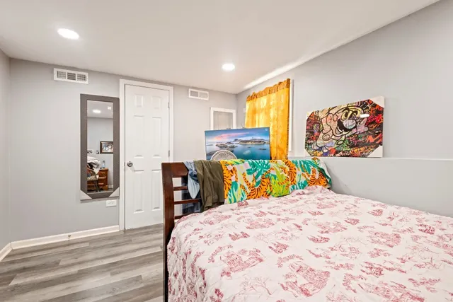 a bedroom with a bed and wooden floor