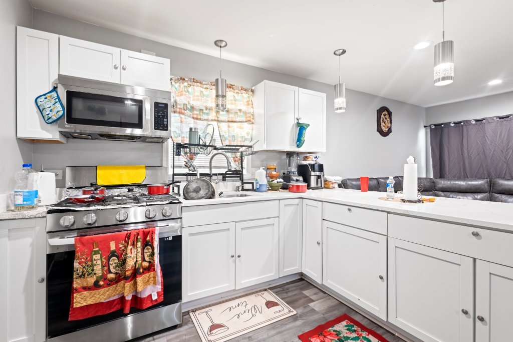 14564 Spaulding Avenue Harvey, IL 60426 - Photo 6 of 20 a kitchen with stainless steel appliances a stove a sink and a microwave