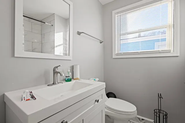 a bathroom with a sink a toilet and a window