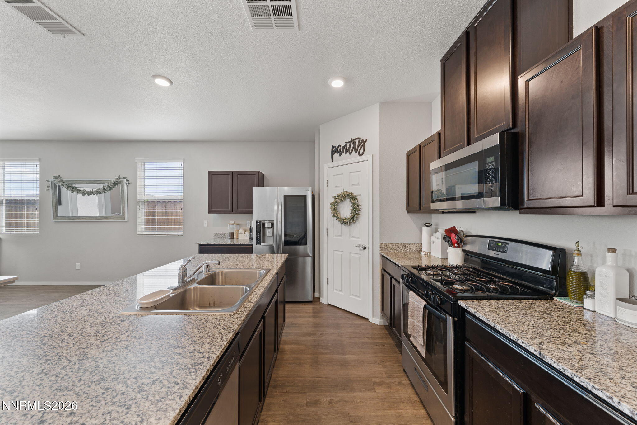 9708 Sea Glass Drive Reno, NV 89506 - Photo 33 of 51 a kitchen with stainless steel appliances granite countertop a sink stove microwave and refrigerator