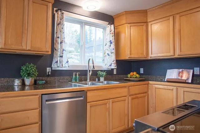 a kitchen with stainless steel appliances granite countertop a sink a refrigerator and cabinets