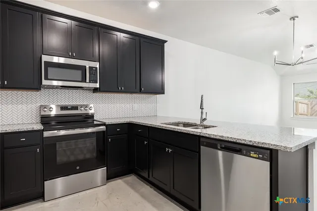 a kitchen with stainless steel appliances a sink stove and microwave