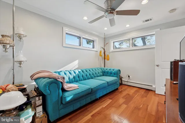 a living room with furniture and a wooden floor