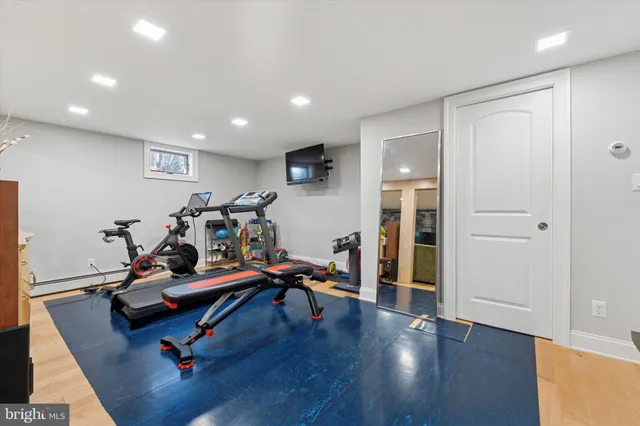 a room with gym equipment and wooden floor