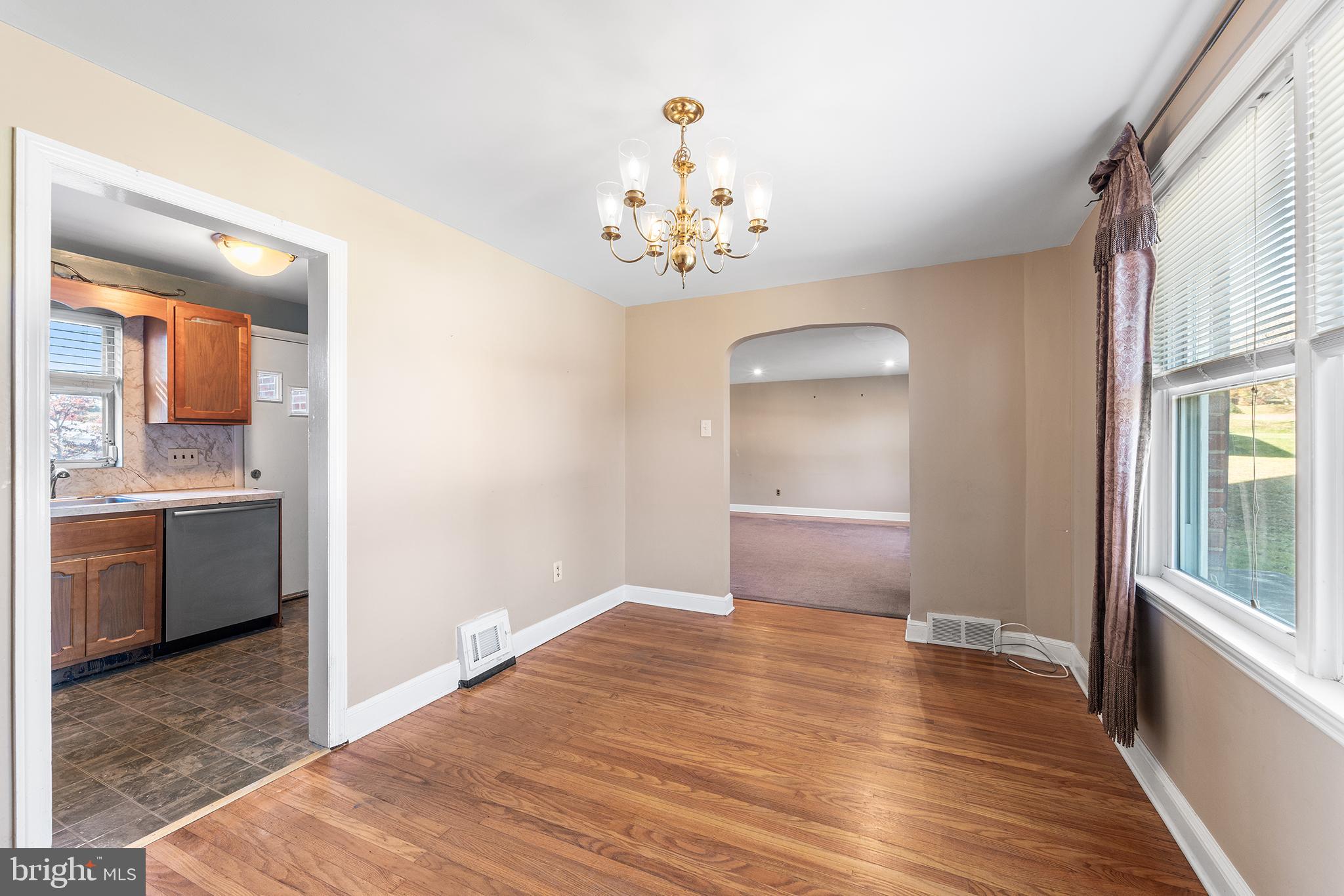 104 Brentwood Road Havertown, PA 19083 - Photo 10 of 28 a view of an empty room with a kitchen and wooden floor