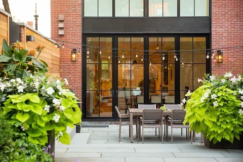 a view of balcony with chairs and potted plants