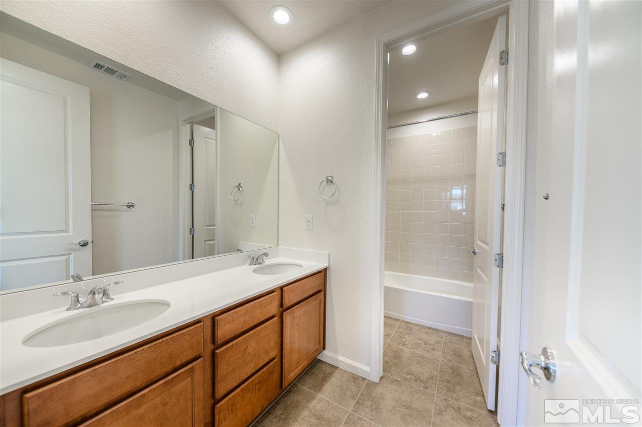 9257 Blue Basin Trail, Unit HOMESITE 16 Reno, NV 89521 - Photo 17 of 22 a bathroom with a sink double vanity granite tub and shower