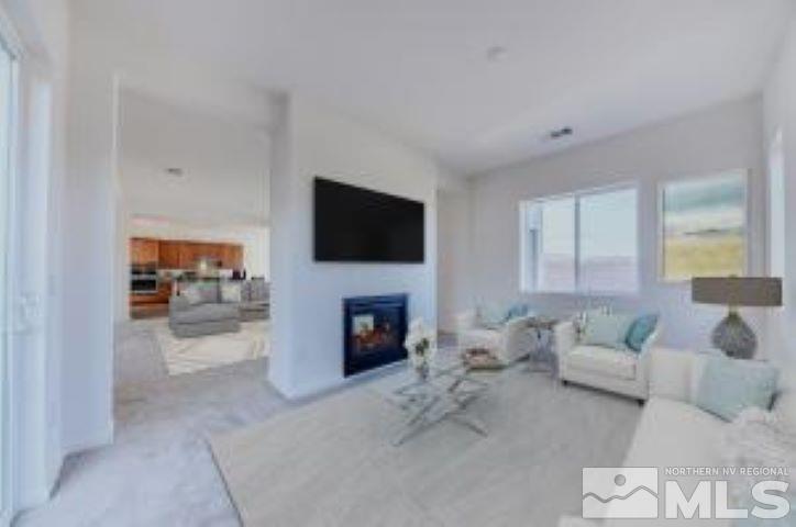 9257 Blue Basin Trail, Unit HOMESITE 16 Reno, NV 89521 - Photo 4 of 22 a living room with furniture a fireplace and a flat screen tv