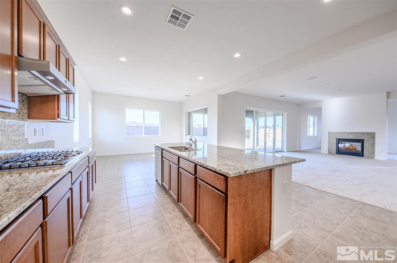 9257 Blue Basin Trail, Unit HOMESITE 16 Reno, NV 89521 - Photo 9 of 22 a kitchen with granite countertop cabinets a sink dishwasher and a stove
