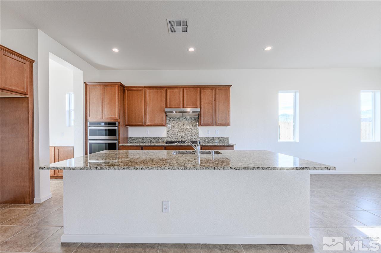 9257 Blue Basin Trail, Unit HOMESITE 16 Reno, NV 89521 - Photo 10 of 22 a kitchen with granite countertop a sink a stove and a refrigerator