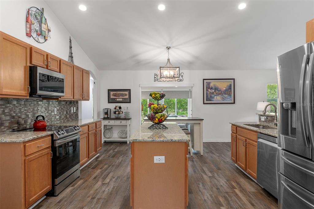 7 Bigleaf Court Homosassa, FL 34446 - Photo 25 of 71 a kitchen with stainless steel appliances granite countertop a refrigerator a stove top oven a sink dishwasher and white cabinets with wooden floor