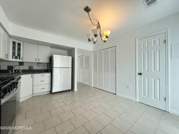 a kitchen with stainless steel appliances granite countertop a refrigerator a stove and white cabinets