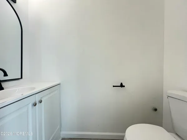 a bathroom with a granite countertop toilet and a sink
