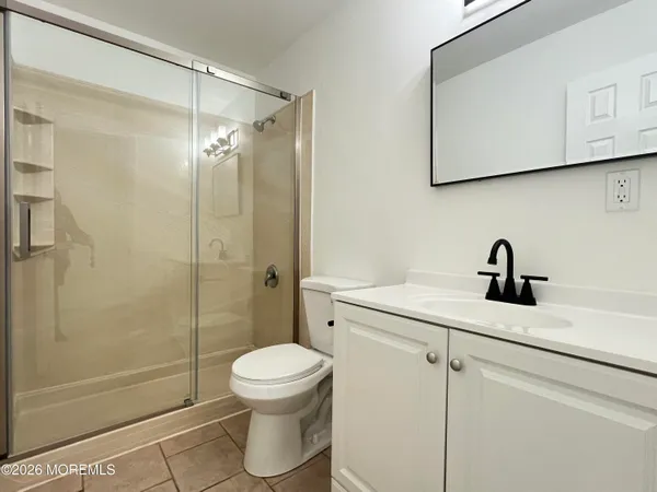 a bathroom with a shower sink vanity and toilet