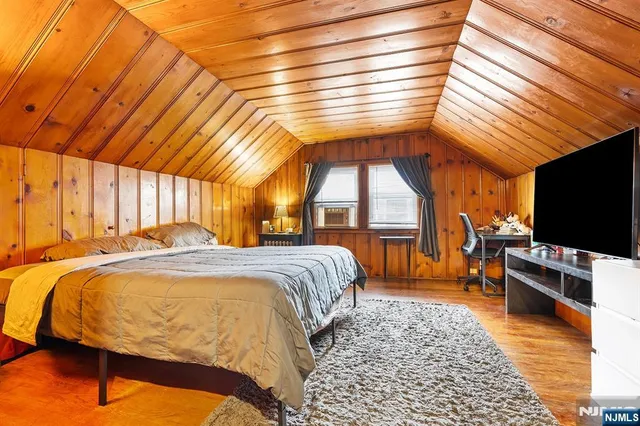 a bedroom with a bed and a flat tv screen