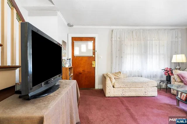 a living room with a flat screen tv furniture and a window