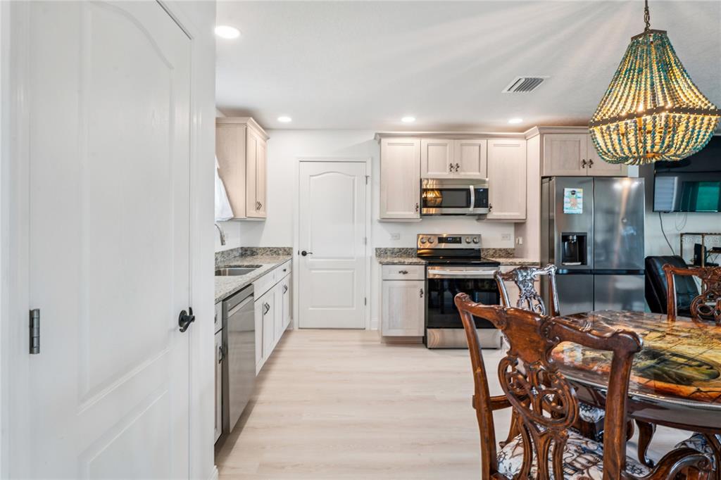 3270 Hibiscus Drive Hernando Beach, FL 34607 - Photo 12 of 75 a kitchen with granite countertop a stove top oven a sink dishwasher a dining table and chairs with wooden floor