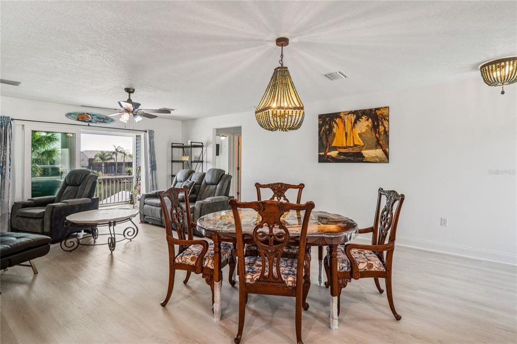 3270 Hibiscus Drive Hernando Beach, FL 34607 - Photo 15 of 75 a view of a dining room and livingroom with furniture wooden floor a chandelier