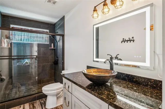 a bathroom with a granite countertop sink and a mirror