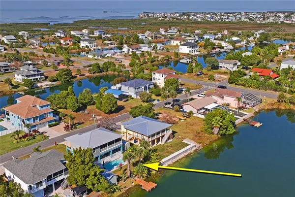 an aerial view of a city with lots of residential buildings and ocean view in back