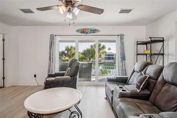 a kitchen with granite countertop a stove top oven a sink dishwasher a dining table and chairs with wooden floor