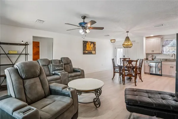 a view of a dining room and livingroom with furniture wooden floor a chandelier