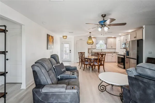 a kitchen with stainless steel appliances a table chairs refrigerator and microwave