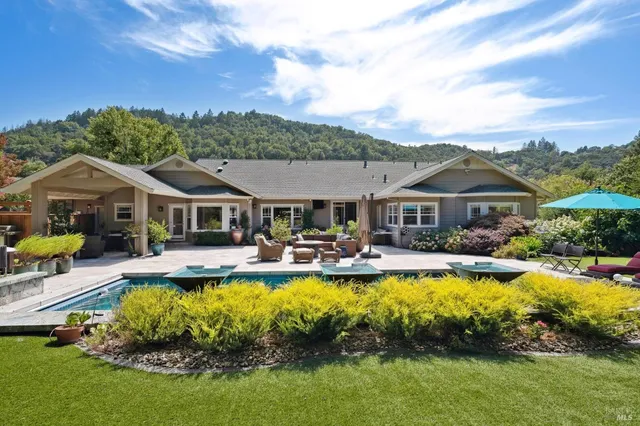 a front view of house with swimming pool and furniture