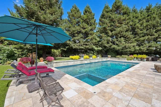 a view of a swimming pool with chairs and an umbrella