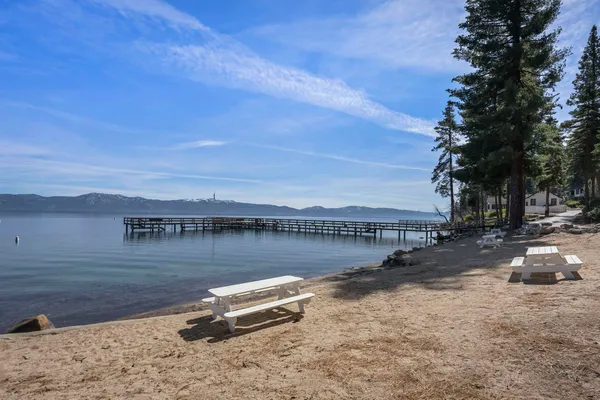 a view of a lake with a table and chairs under an umbrella