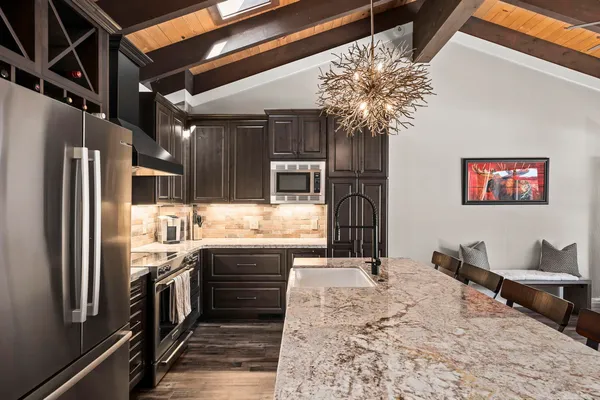 a kitchen with stainless steel appliances kitchen island granite countertop a refrigerator and a sink